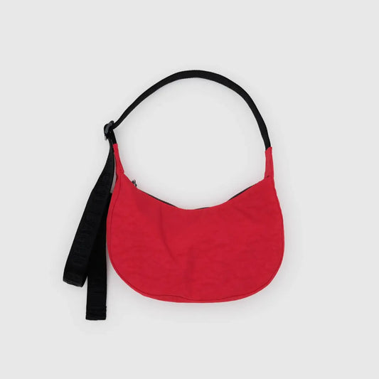 Red handbag with a black strap on a light gray background